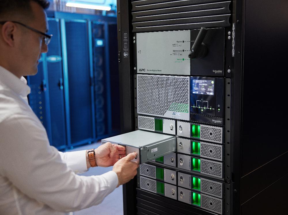 Técnico instalando un módulo en un sistema APC Smart-UPS Modular Ultra de Schneider Electric